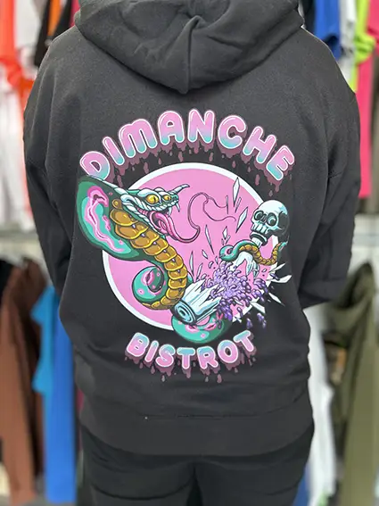 Sweat à capuche noir imprimé au dos du visuel coloré « Dimanche Bistrot »