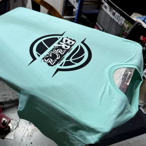 T-shirt vert d’eau sérigraphié en noir et blanc d’un logo de basket, sur le carrousel de l’atelier HOP Textile
