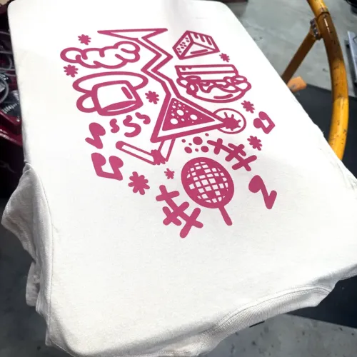 T-shirt blanc sérigraphié d’un grand visuel rose, sur le carrousel de l’atelier HOP Textile